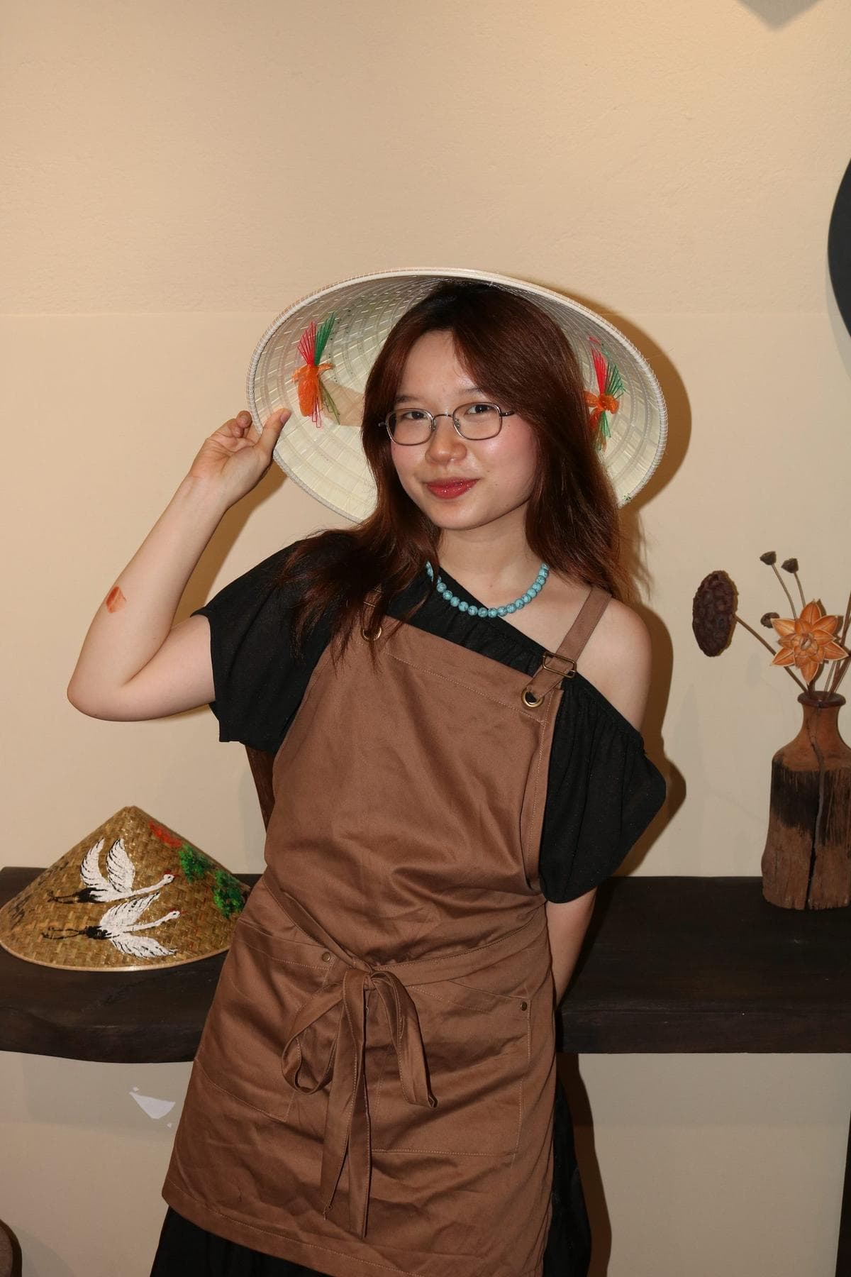 The founder of Faifo Art, wearing a hand-painted conical hat