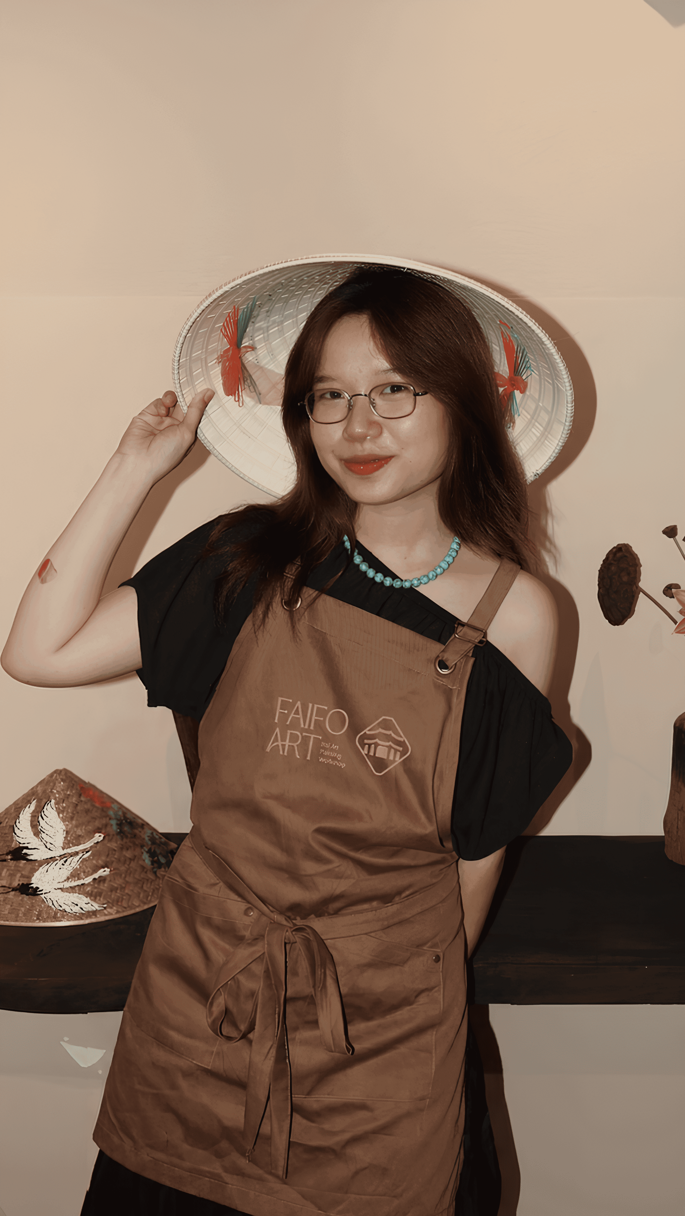 The founder of Faifo Art, wearing a hand-painted conical hat