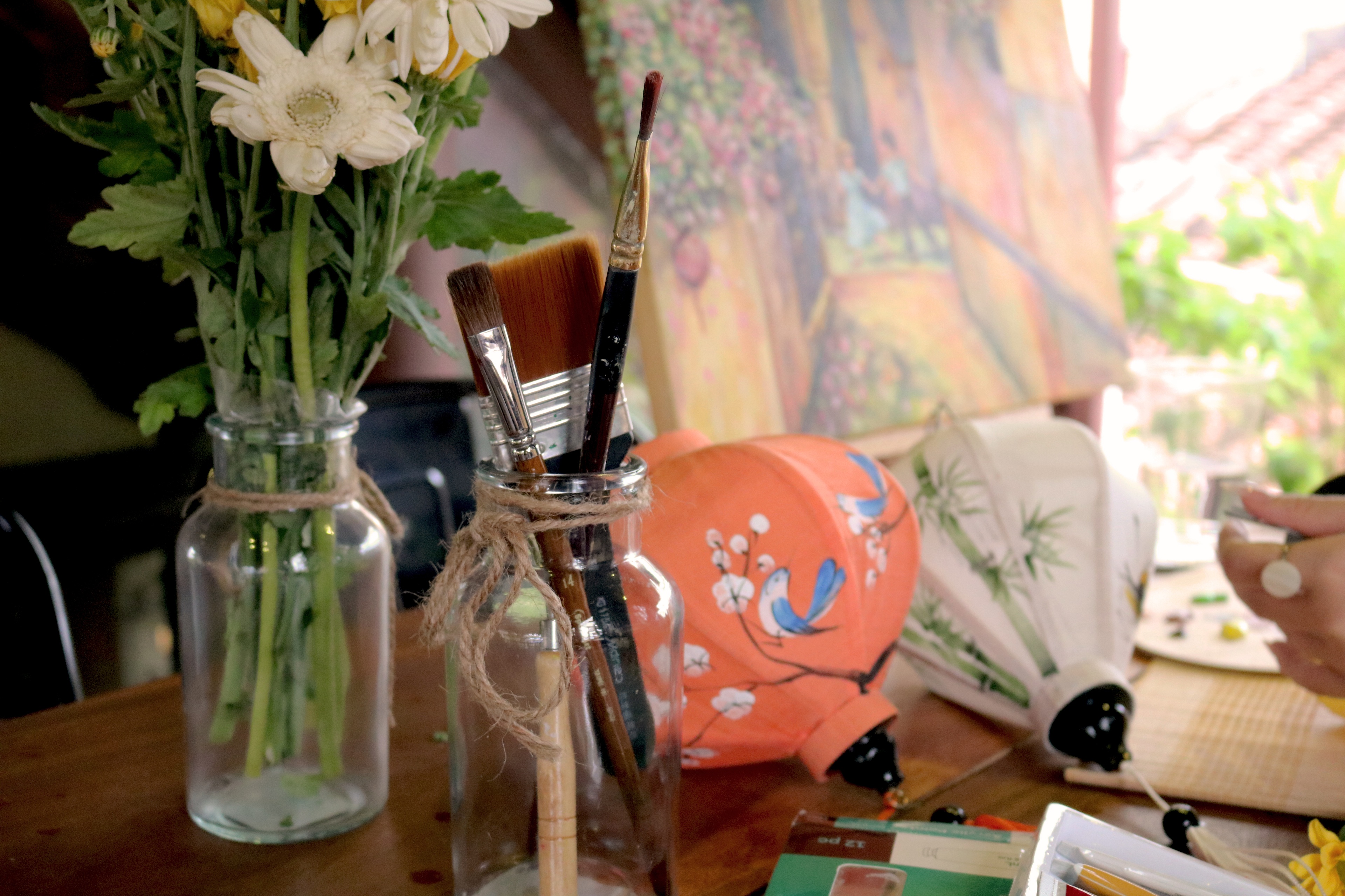 Brushes, paints and a lantern ready on the table