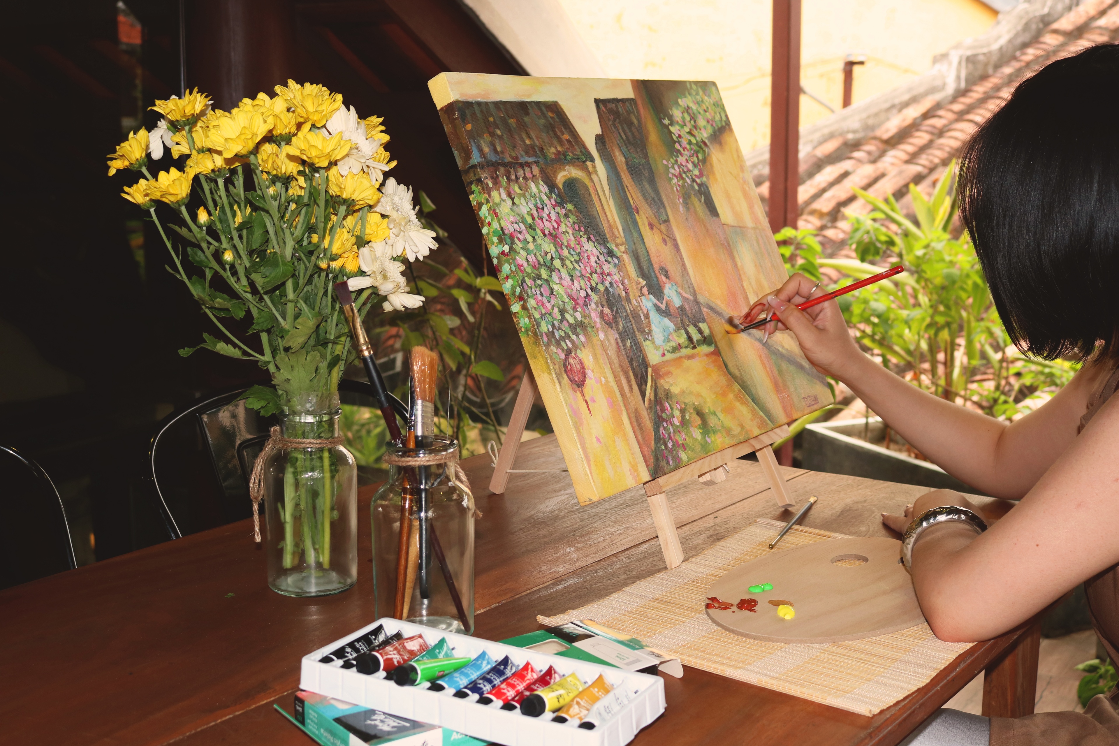 A guest painting a canvas at the studio